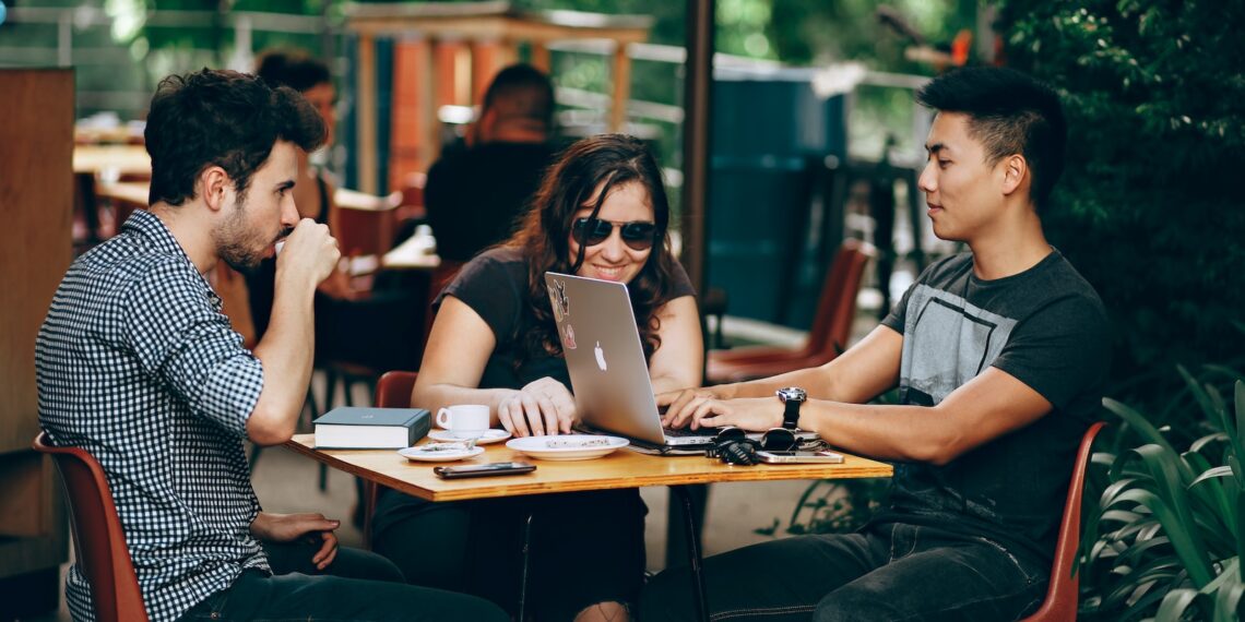 photo of three person sitting and talking